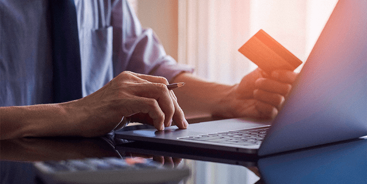 An adult using a laptop to make a digital payment.